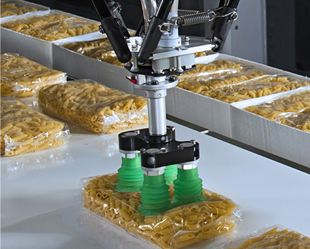 Delta robots pick pasta in plastic bags and place them in a cardboard box.