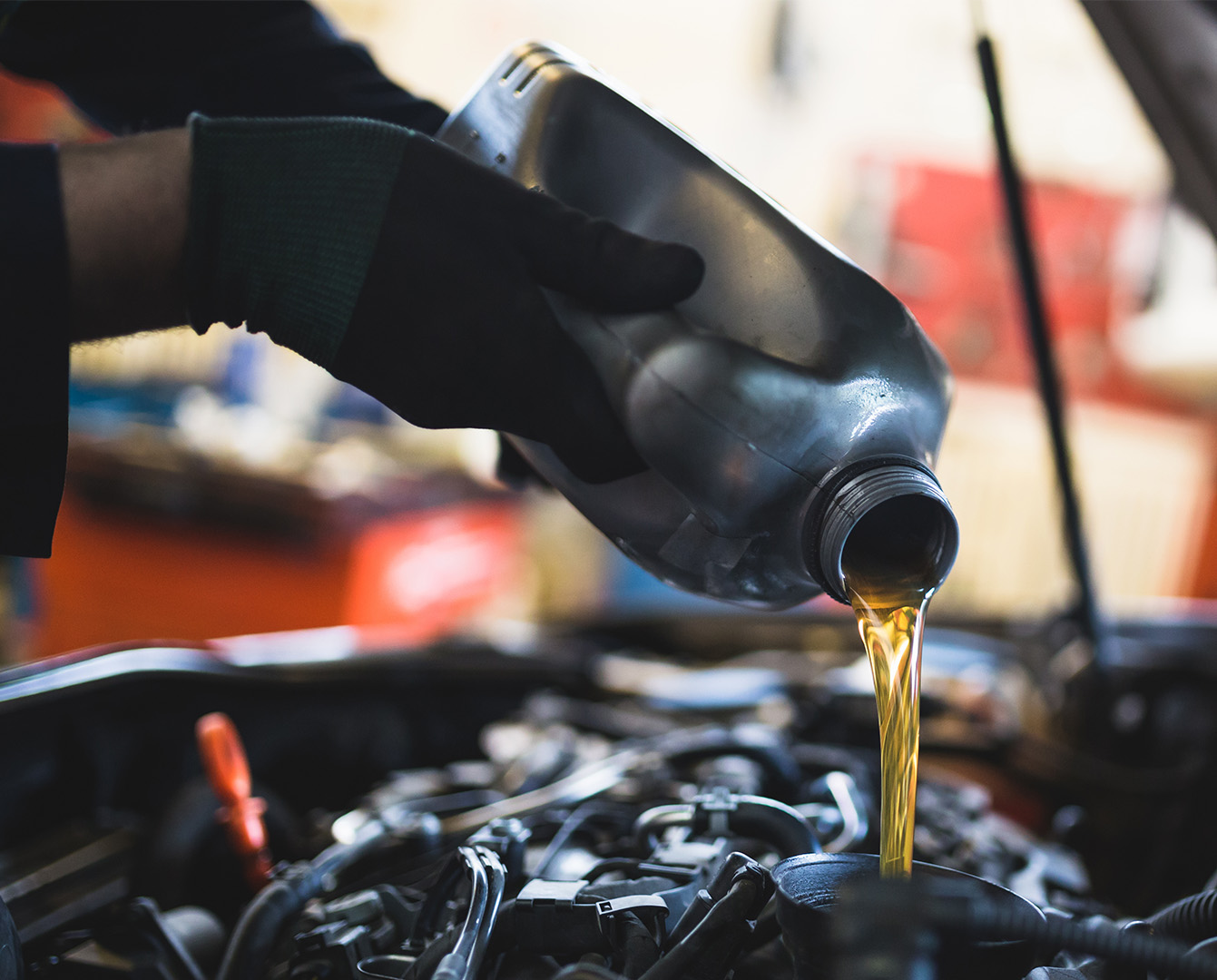 Oil container filling a car's radiator 