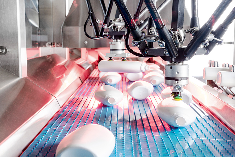 Delta robots of a pickFeeder unscrambler picking plastic bottles.