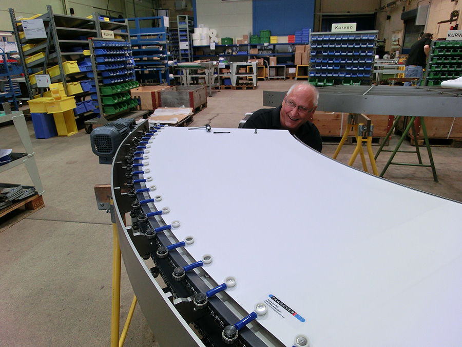 Transver employee assembles a curved conveyor belt.